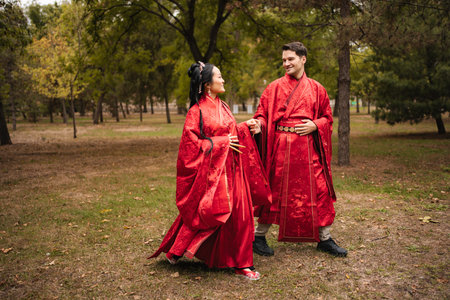 Interracial couple celebrating wedding wearing traditional red Chinese hanfuの写真素材