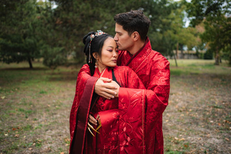 Loving interracial couple celebrating traditional Chinese wedding ceremonyの写真素材