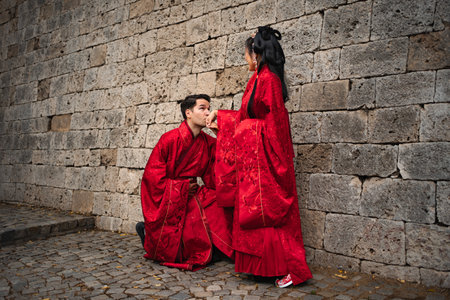 Intercultural couple celebrating wedding in traditional Chinese clothingの写真素材