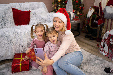 Mother and daughters taking selfie with Christmas presentsの写真素材
