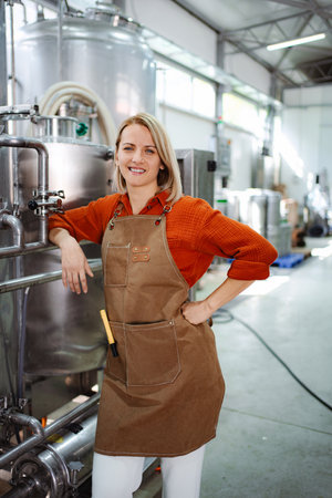 Female brewer smiling in a modern craft beer breweryの写真素材