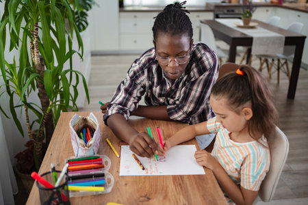 Creative bonding moments between a child and adult at homeの写真素材