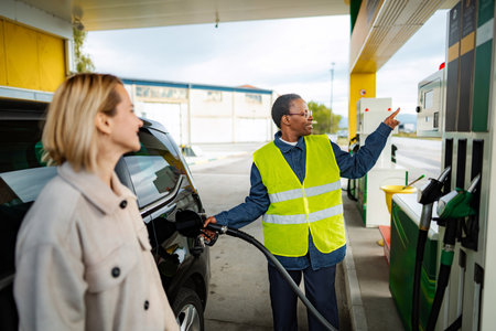 Service worker assisting woman refueling car at gas station