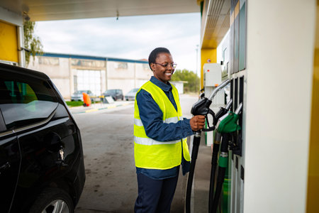 Woman worker smiling while refueling car at gas station
