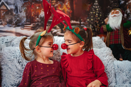Little girls wearing reindeer costumes celebrating Christmas holidayの写真素材
