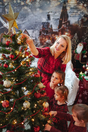 Family enjoying decorating Christmas tree together in festive settingの写真素材