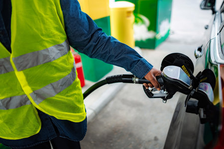 Person refueling car with diesel at gas stationの写真素材