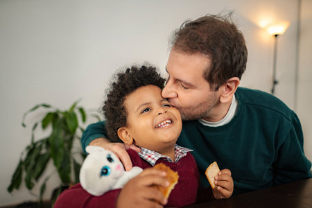 Loving father kissing happy son expressing bond at home