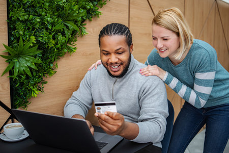 Happy interracial couple online shopping using credit card