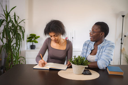 Mother Helping Teenage Daughter With Homework At Homeの写真素材