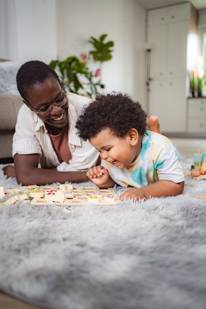 Mother and son playing wooden puzzle on rugの写真素材
