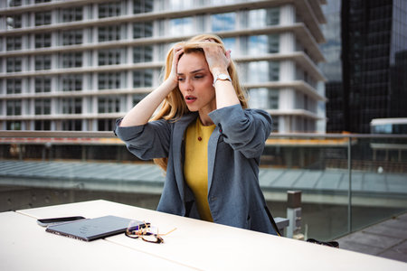 Stressed businesswoman experiencing burnout and work pressure in cityの写真素材