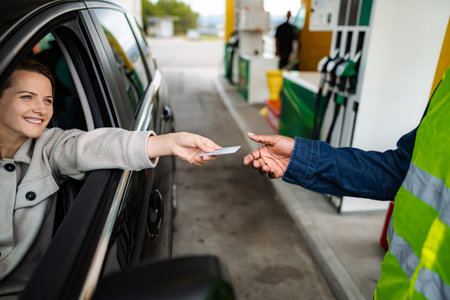 Woman paying for gas with credit card at service stationの写真素材
