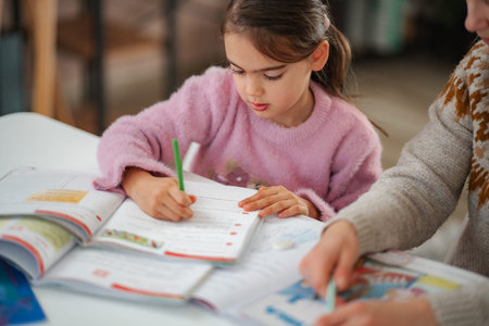 Young girl learning and writing with an adult helpingの写真素材