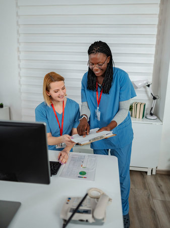 Diverse medical staff collaborating on patient charts in office