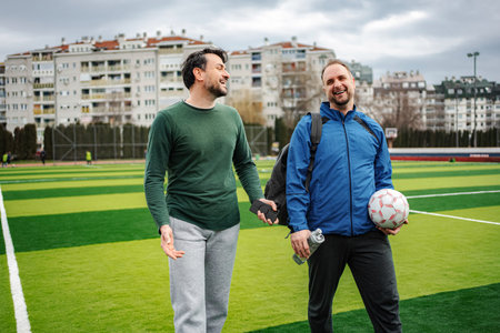 Two men walking on soccer field after playing