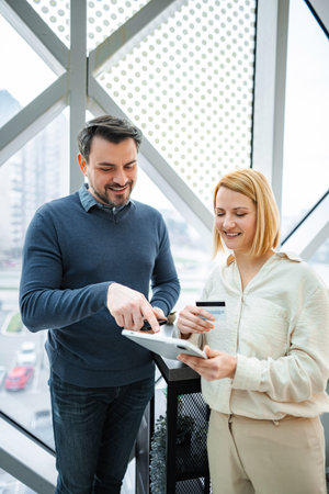 Business partners making online payment using tablet and credit card