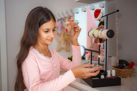 Teen girl choosing jewelry from her vanity at homeの写真素材