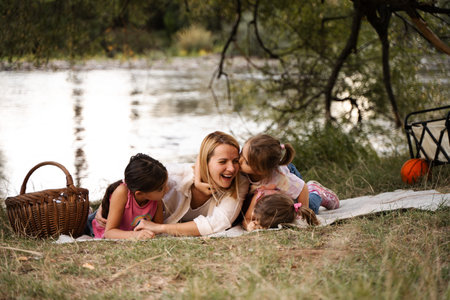 Happy family enjoying a picnic by the river having fun and kissing