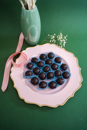 Chocolate truffles serving on elegant pink plate with ribbon