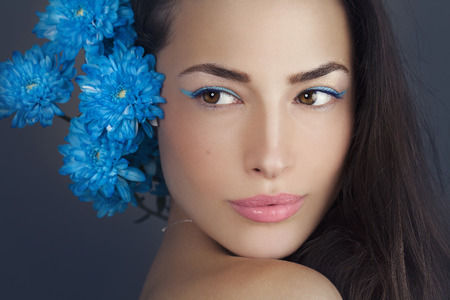 woman beauty portrait with blue flowers close to the headの写真素材
