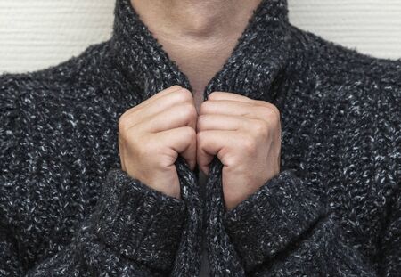 a man wraps himself in a warm sweaterの写真素材