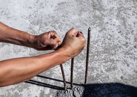 male hands unbend iron rods