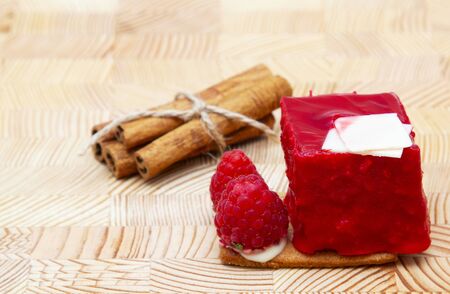 stylish new creative raspberry cake on a wooden background and cinnamonの写真素材