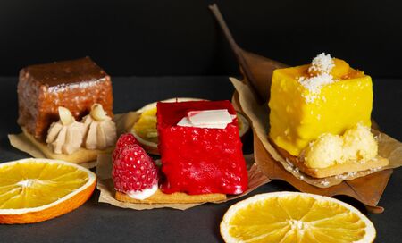 stylish fashionable assortment of lemon raspberry and chocolate cake and orangeの写真素材