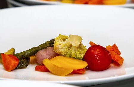 beautifully laid out french steamed vegetables on a white plate close-up