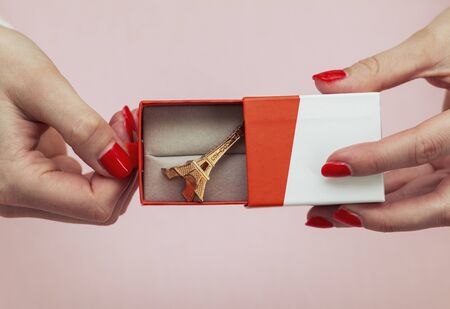 female hands holding a gift box where the eiffel tower lies