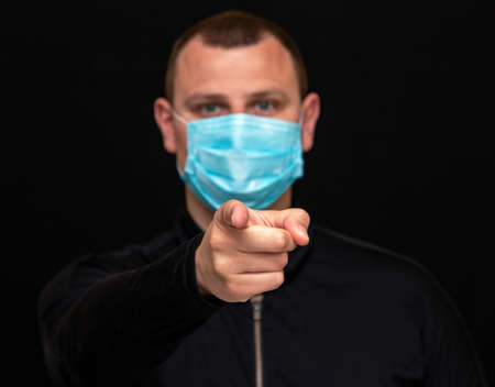 a man points a finger at a patient in a medical mask
