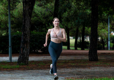 beautiful blonde girl runs in the park