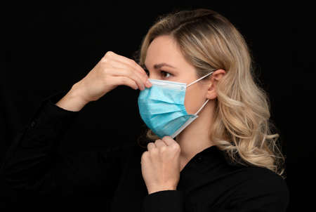 the girl demonstrates how to put on a medical mask