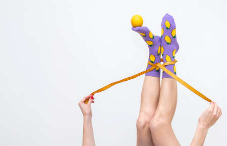 female legs in colorful socks with lemons isolated on white backgroundの写真素材
