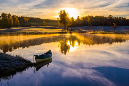 Sunrise over the lake with a boatの写真素材