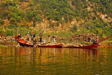 Vietnam men mining and driving wood on the riverの写真素材