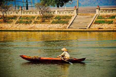 Old vietnam woman on the boat on riverの写真素材