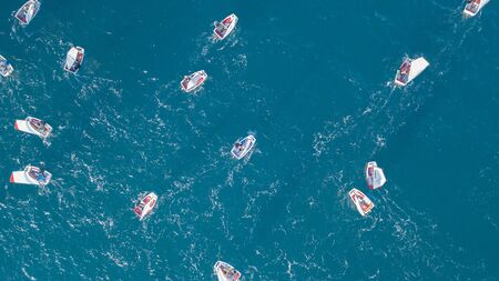 Group of small sail boats manoeuvring in the calm sea waters. Aerial viewの写真素材