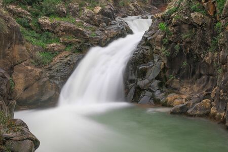 Waterfall and greenery all around. Long exposure photography.の写真素材