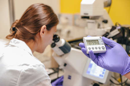 Scientists perform scientific research with the help of a microscope in the laboratory.
