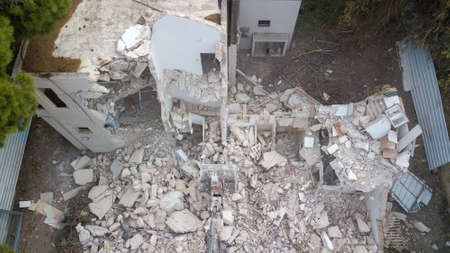Excavator demolishing barracks for new construction project.