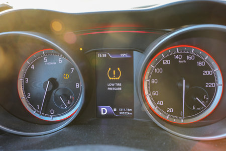 Low tire pressure error sign. Warning lights flash on the car dashboard.