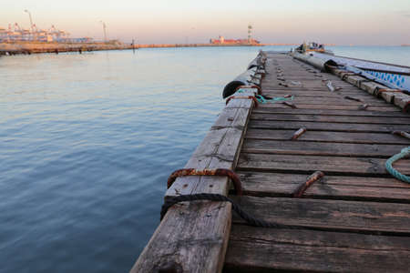 Wooden pier with blue sea. Wood floor or terrace beside the blue crystal clear water and a rope.の写真素材