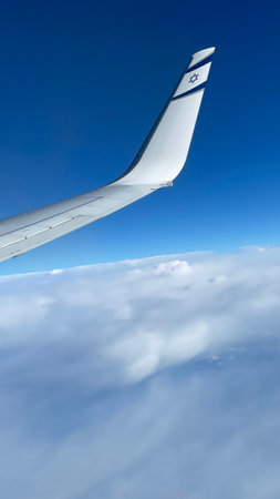 Middle East - April 22, 2023: Wing of the Israeli airline El Al airplane flying above the clouds.