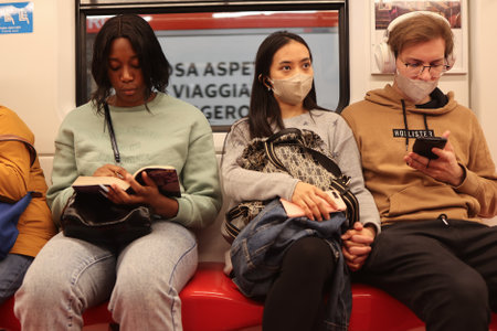 MILAN, ITALY - October 22, 2022: People of different ethnicities sit next to each other in the metro.のeditorial素材