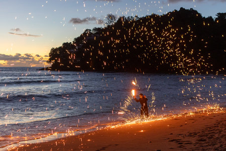 A Dynamic Fire Performerat the Beach During the Beautiful Sunset.の写真素材