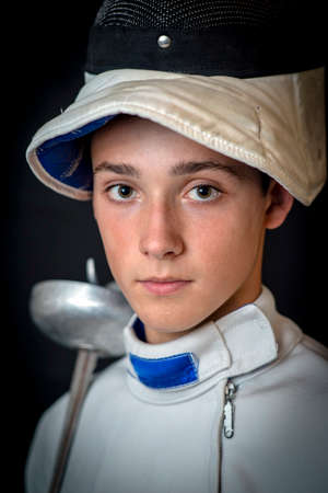 a young man in a swordsman's ammunition with a sword in a cookの写真素材