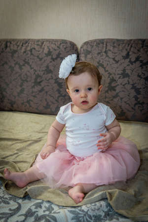 little girl on the couch in a pink skirtの写真素材