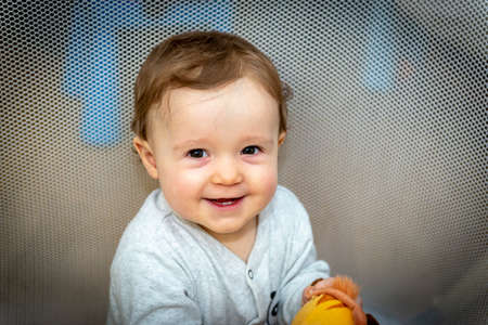 a little baby girl is sitting in an aviary with toysの写真素材